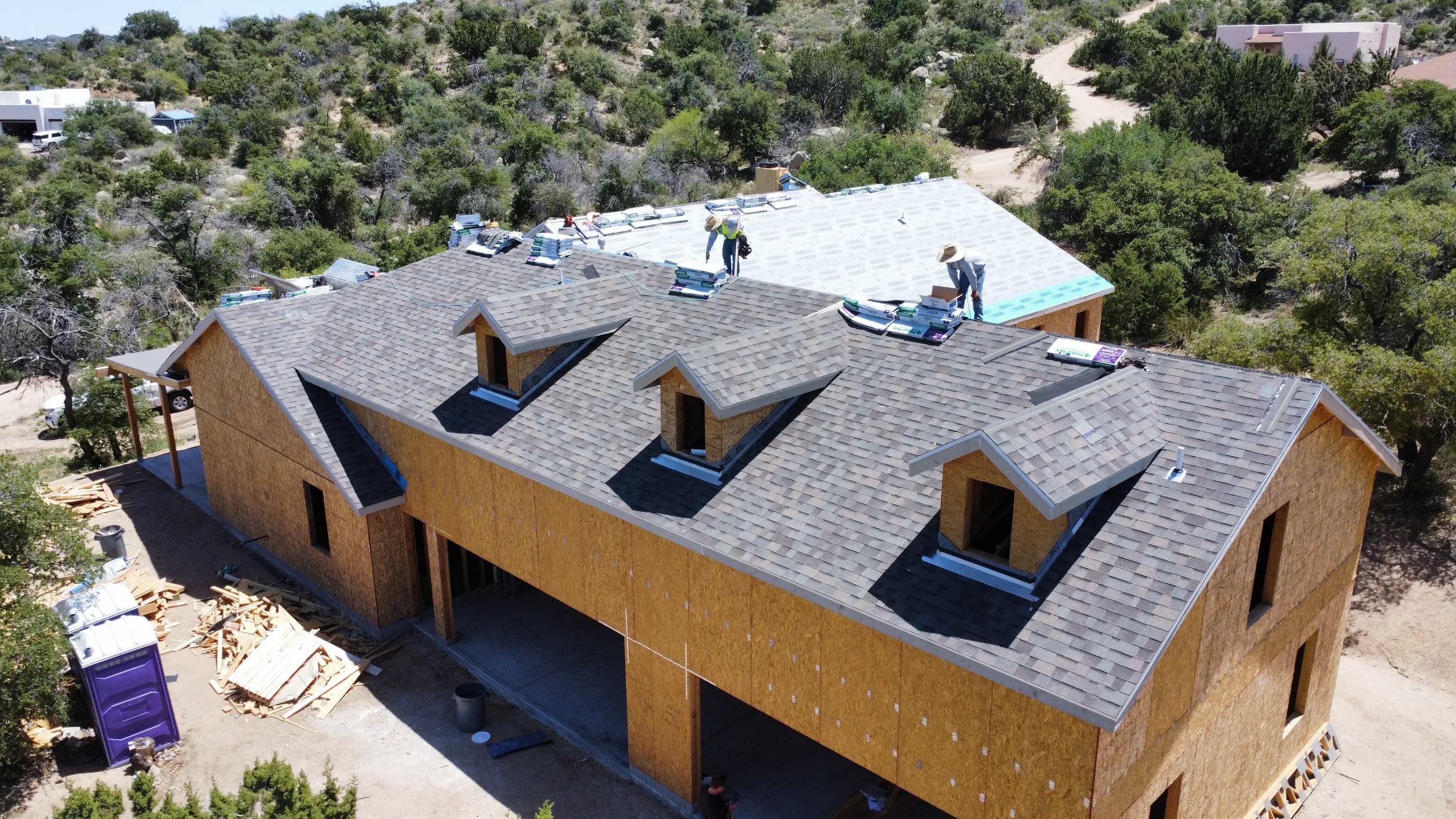Finished architectural-shingle roof on a custom new-build home outside Oracle, Arizona, overhead drone view