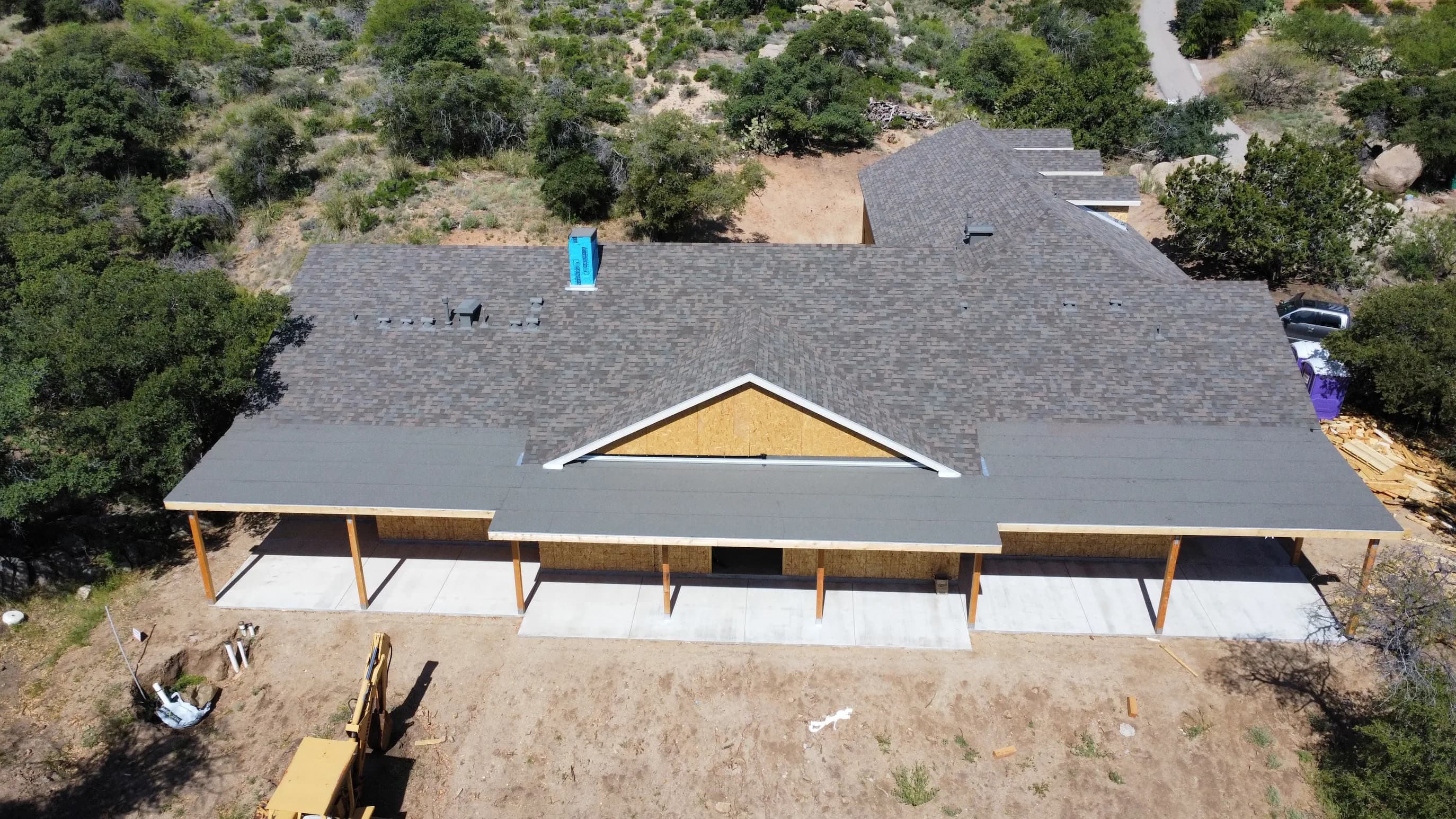 Mid-install — shingles coursing up around multiple dormer transitions