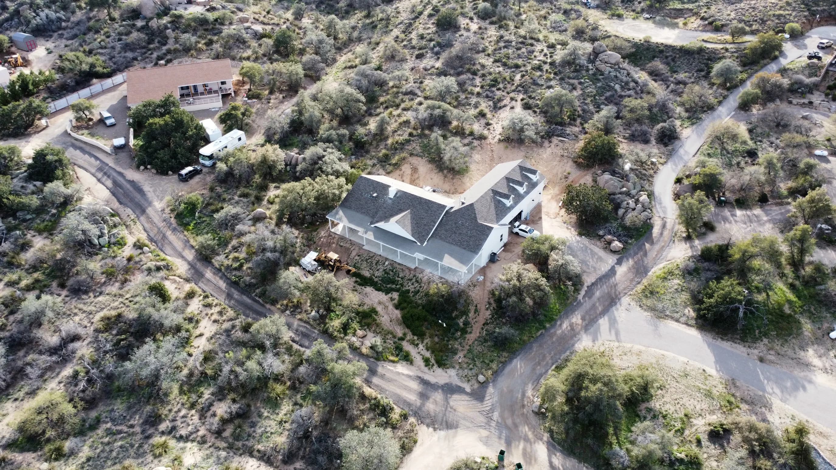 Crew working ridge-cap detail on a steep custom hillside home